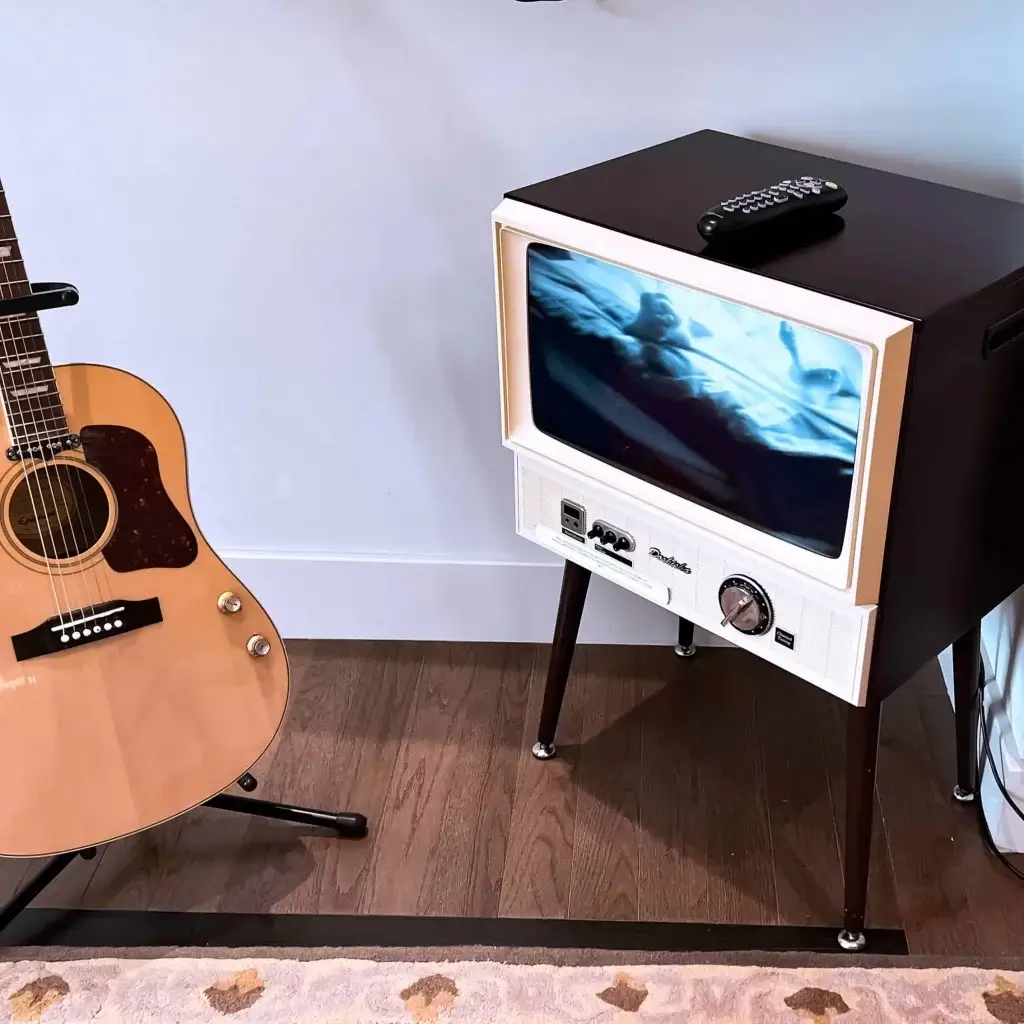 Guitare acoustique et téléviseur d'époque dans la suite John Lennon et Yoko Ono