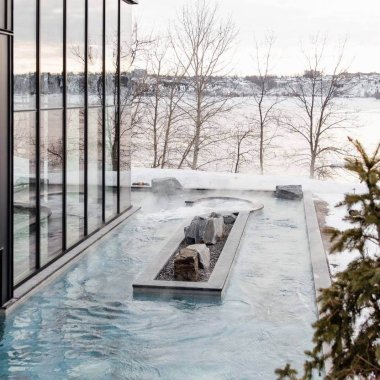 Bains extérieurs du Strøm spa nordique Vieux-Québec face au fleuve Saint-Laurent en hiver