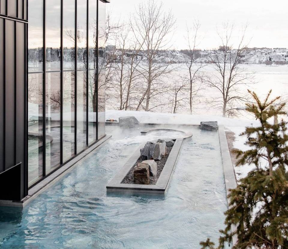 Bains extérieurs du Strøm spa nordique Vieux-Québec face au fleuve Saint-Laurent en hiver