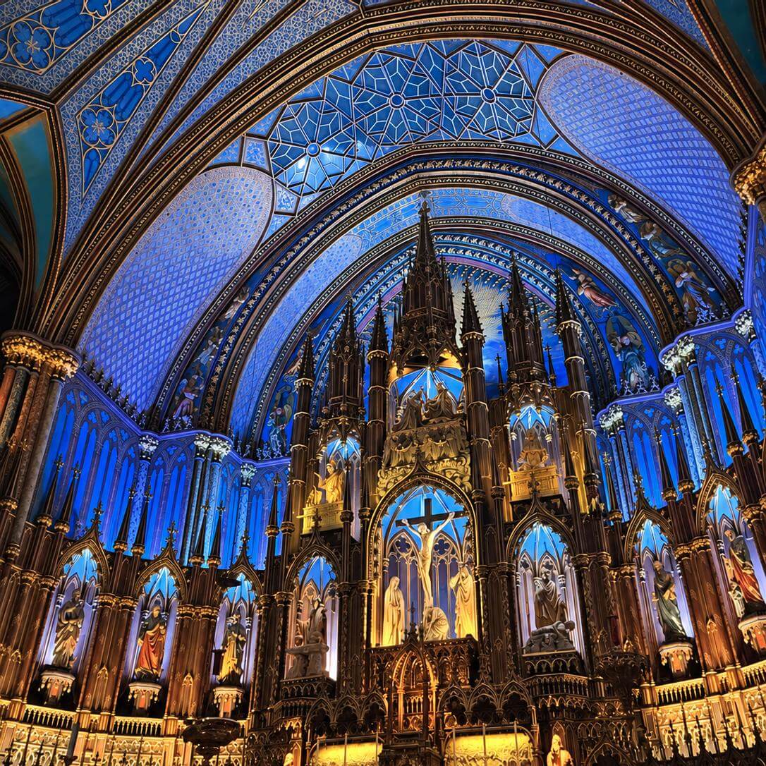 Intérieur illuminé de la basilique Notre-Dame de Montréal, avec sa voûte bleue et son retable doré