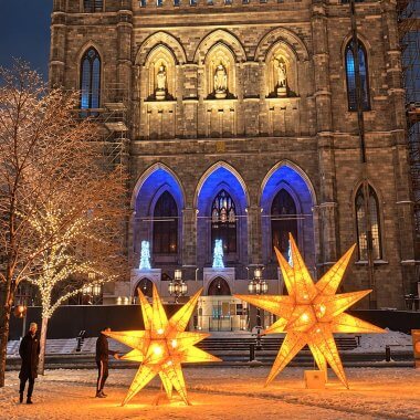 Étoiles lumineuses géantes sur la place d’Armes enneigée, devant la basilique Notre-Dame de Montréal