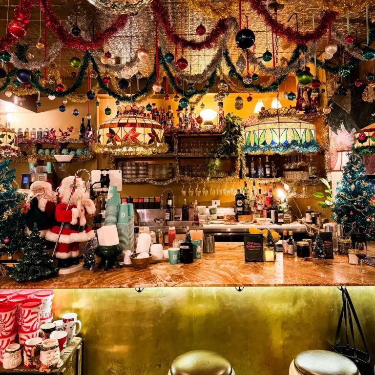 Comptoir de la Taverne de Noël à Montréal décoré de guirlandes, de boules de Noël et de Pères Noël