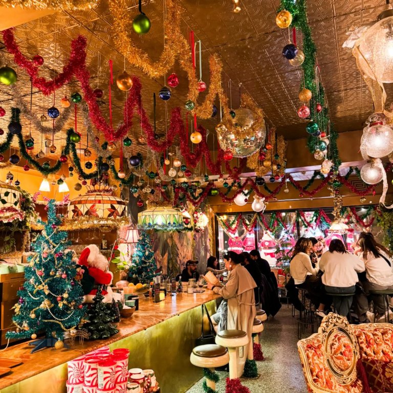 Salle de la Taverne de Noël à Montréal avec sapins, guirlandes, boules dorées et lustres vintage